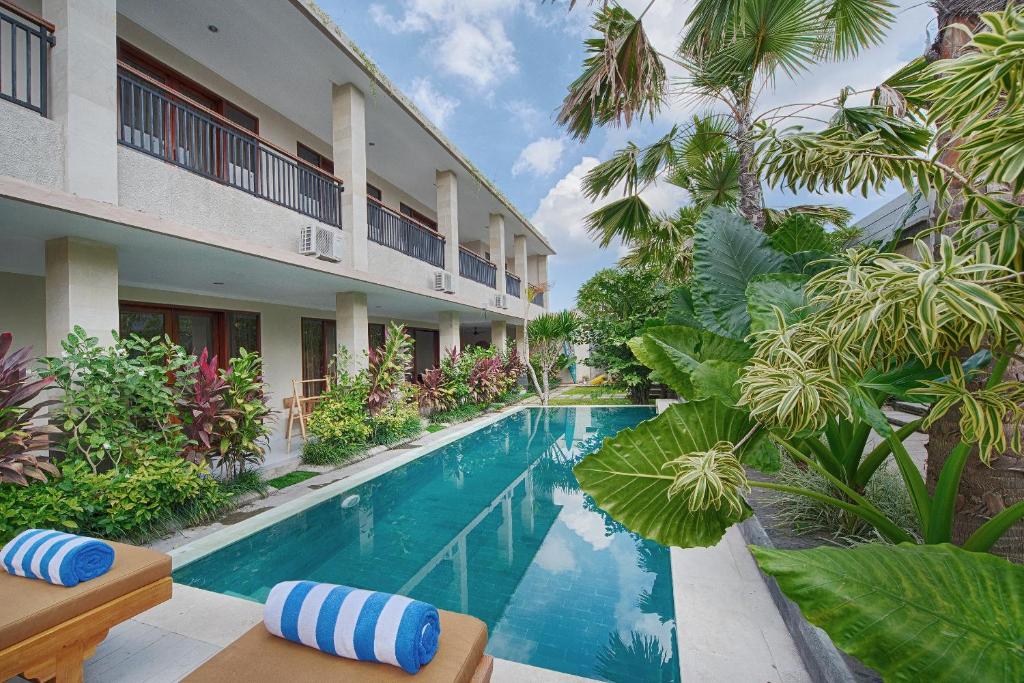 a swimming pool in front of a building at Puri Canggu Villas & Rooms in Canggu