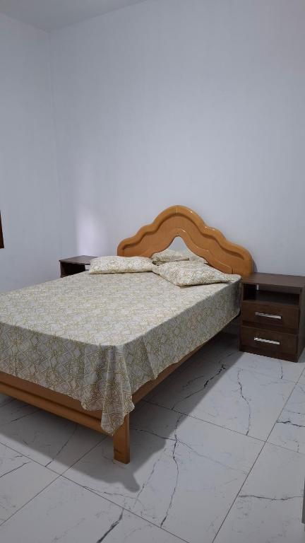 a bed with a wooden frame in a room at Casa Verão Cananéia in Cananéia