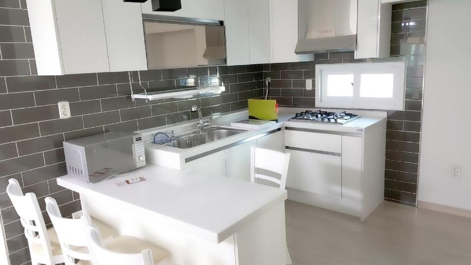 a white kitchen with a sink and a stove at 인천인하우스 