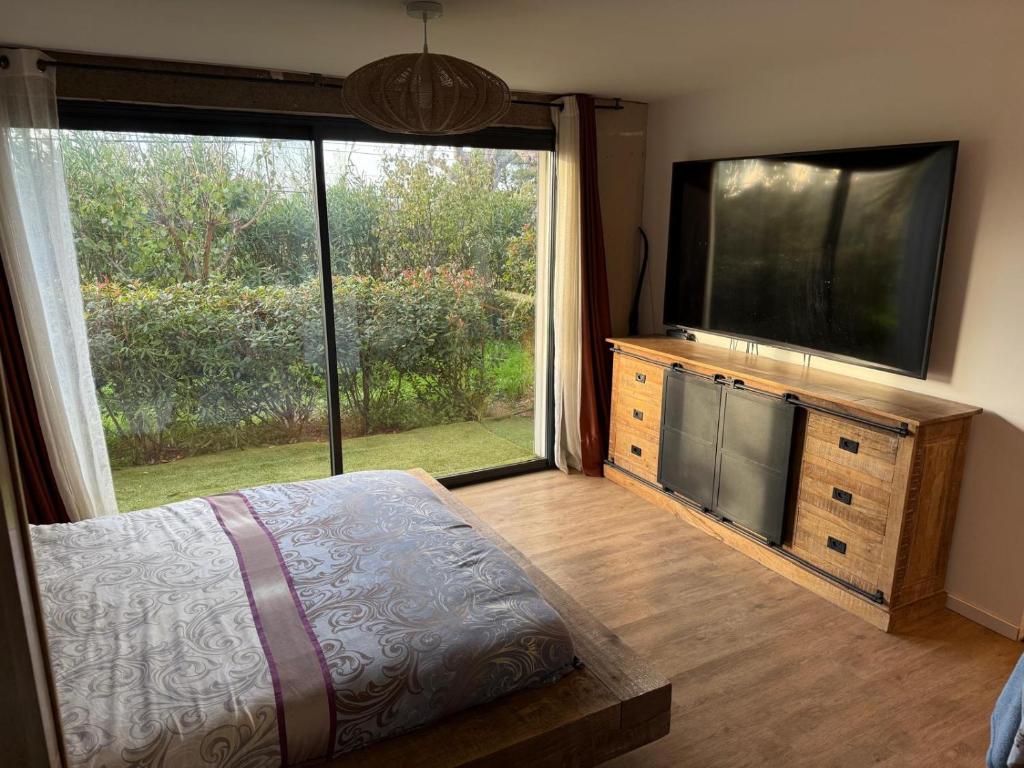 a bedroom with a flat screen tv and a large window at Villa Le M in Six-Fours-les-Plages