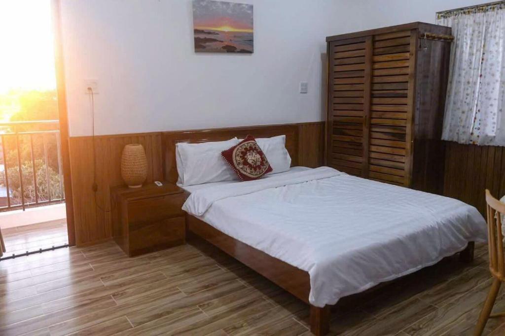 - une chambre avec un lit, une commode et une fenêtre dans l'établissement Homestay Gio bien, à Ấp Ngọc Hải