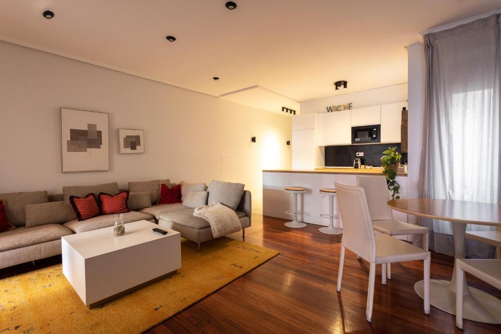 a living room with a couch and a table at New Bilbao city center in Bilbao