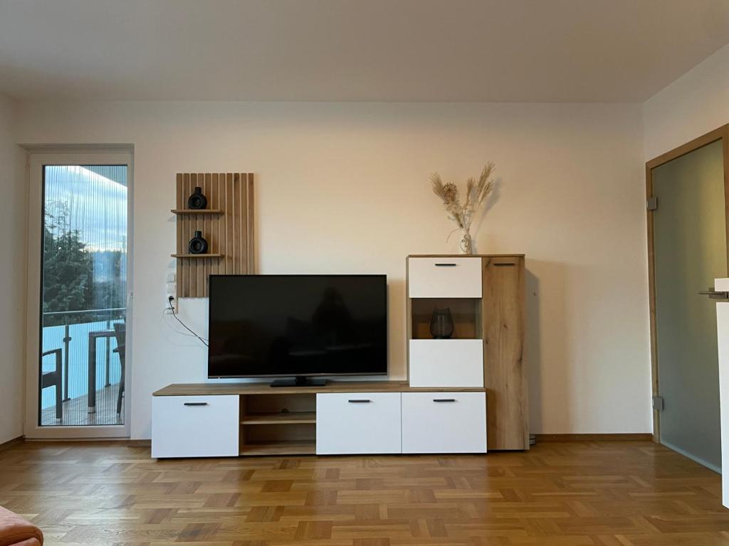 a living room with a flat screen tv on a stand at Ferienwohnung Adelsried 2 in Adelsried