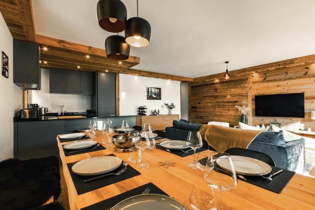a dining room with a table with wine glasses on it at Centre Les Gets with 2 parking and Slope views - 6&2 ppl - Asteria in Les Gets