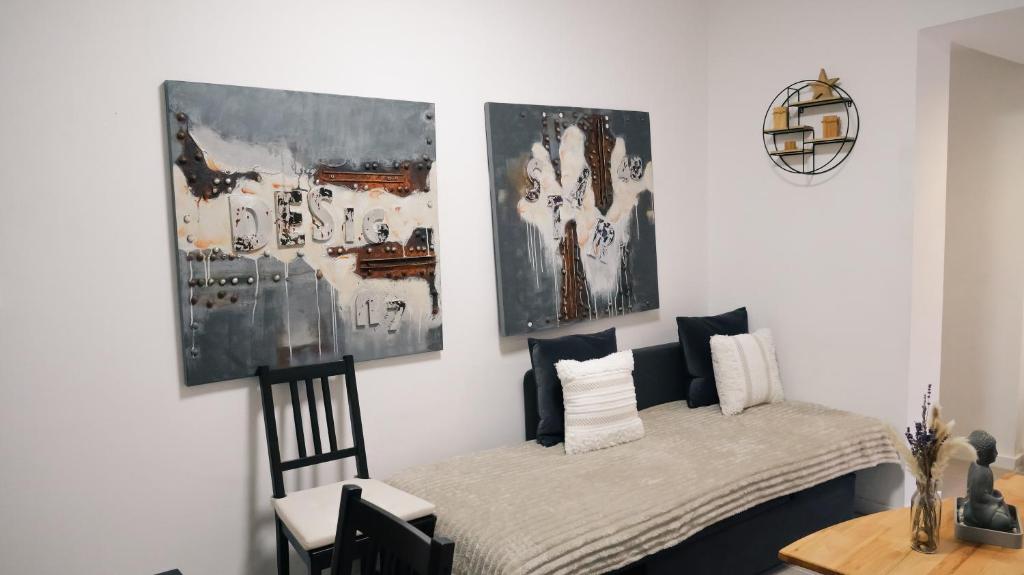 a room with a table and chairs and paintings on the wall at City-Apartment - mit Innenhoflage - Nähe Altstadt & Hbf in Saarbrücken