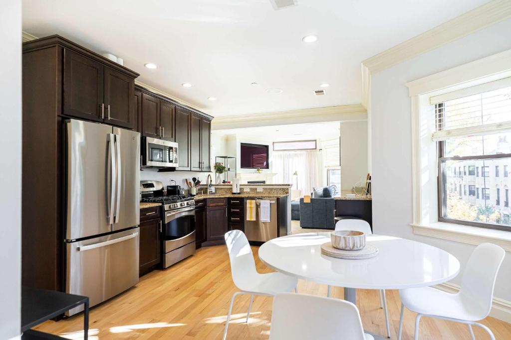 a kitchen with a white table and white chairs at Brownstone Luxury Penthouse Condo in Boston