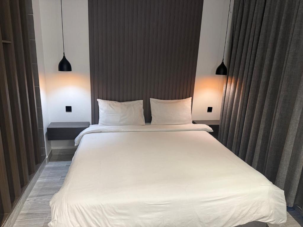 Un dormitorio con una gran cama blanca con dos almohadas. en شاليهات سمو بارك 1, en Taif