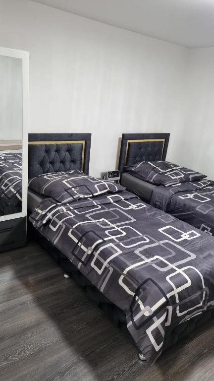 1 Schlafzimmer mit 2 Betten mit einer schwarzen und weißen Bettdecke in der Unterkunft Natur Atmosphäre in Netphen