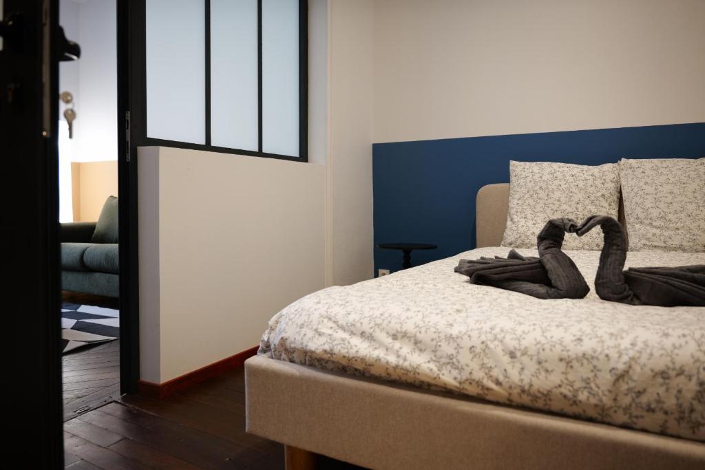 a bedroom with a bed with a pair of shoes on it at bel appartement 2-4 personnes coeur de ville Angers in Angers