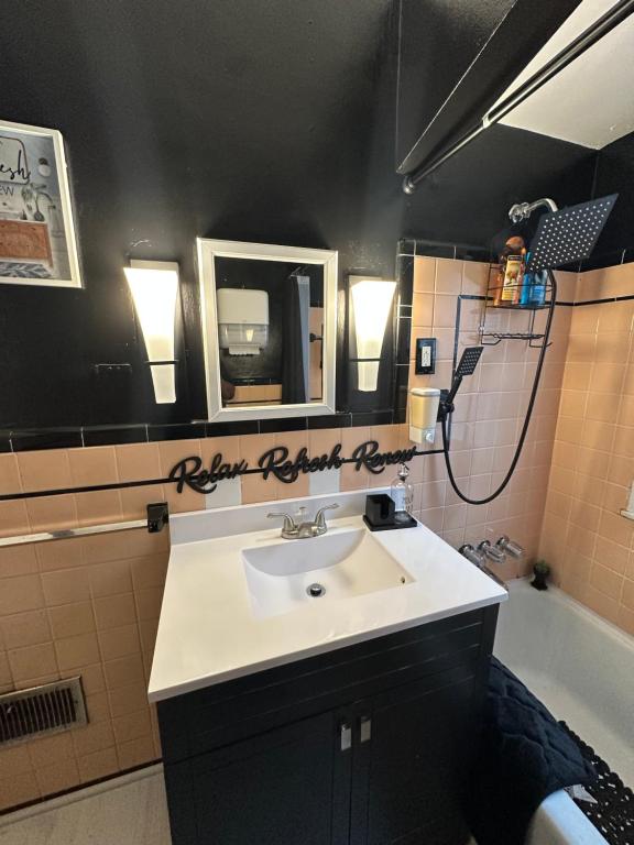 a bathroom with a sink and a mirror and a tub at Home Sweet Home in Detroit