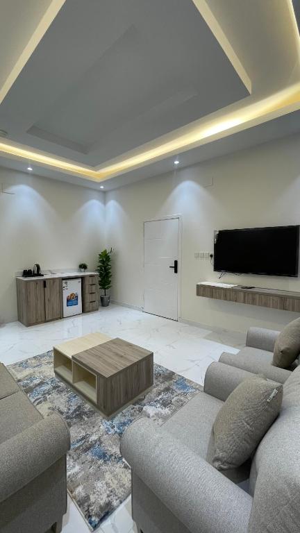 a living room with two couches and a flat screen tv at شقق واڤا in Tabuk