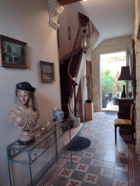 un couloir avec une statue de femme sur une table dans l'établissement Au Gré Du Voyage, à Uzès