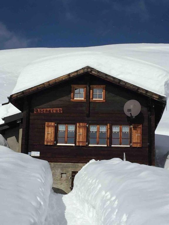 a log cabin with snow on top of it at Chalet Abendruh Belalp in Naters