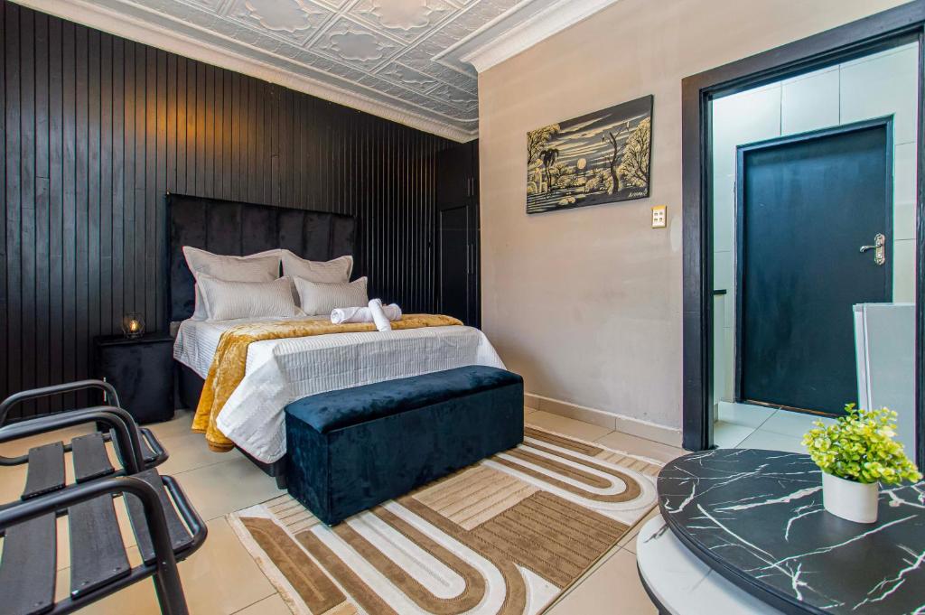 a bedroom with a king sized bed and a couch at WinHaven Guest House in Randfontein