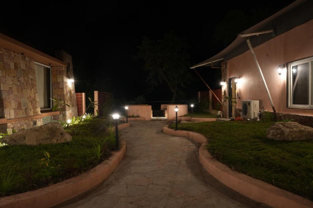 a walkway leading to a house at night at Wild Forest By Nirvana in Sasan Gir