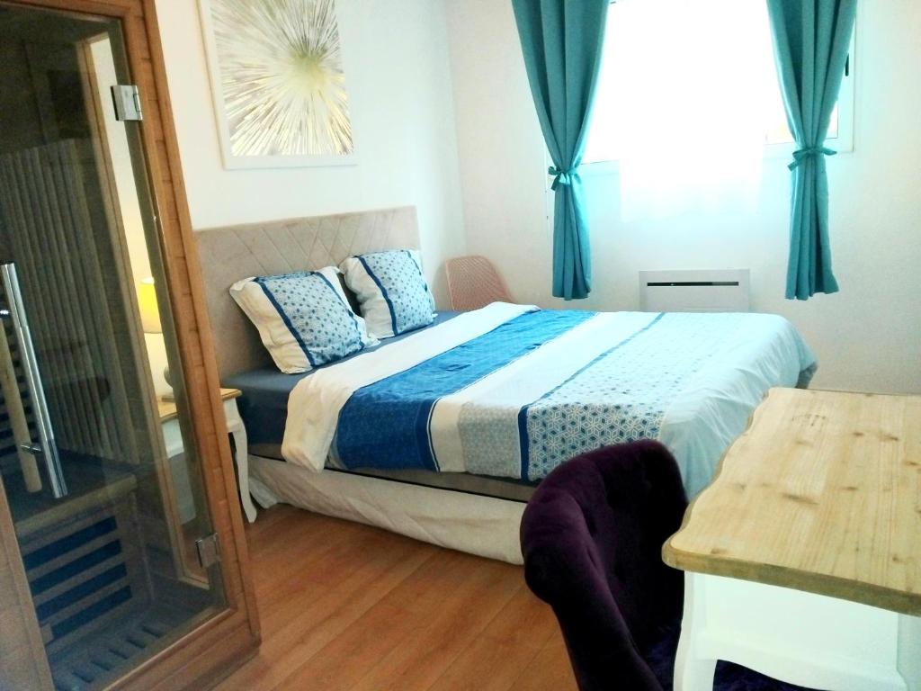 een slaapkamer met een bed met blauwe gordijnen en een spiegel bij Apt au calme, 2-3 chambres, Sauna, 2 parkings, wifi in Montévrain