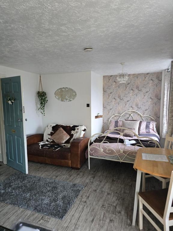 a bedroom with a bed and a couch at Havisham Studio Flat Rochester ME1 1XZ in Strood