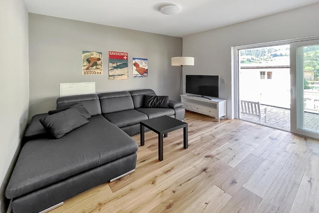 a living room with a couch and a television at Ferienwohnung Tgesa Sulai in Savognin