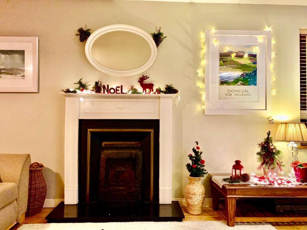 a living room with a fireplace and a mirror at Ballyboe Cottage in Dunfanaghy
