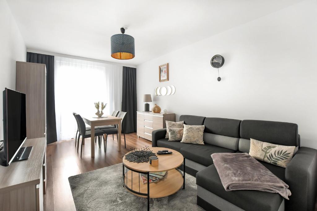 un salon avec un canapé et une table dans l'établissement Green Point Apartment, Sosnowiec City Center, à Sosnowiec