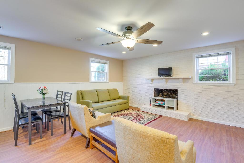 Una sala de estar con un sofá y una mesa con sillas. en 10 Mi to DC Berwyn Heights Apt with Shared Patio!, en Berwyn Heights