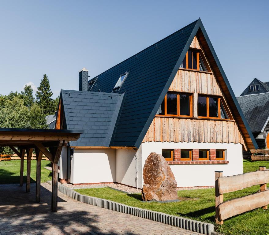 a large wooden barn with a black roof at Ferienhaus Lärchenblick in Kurort Altenberg