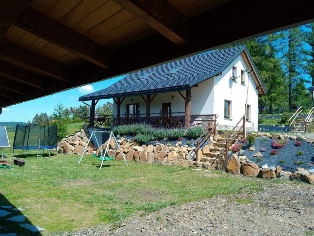a house with a lot of rocks in front of it at Aroniowe Wzgórze in Berezka