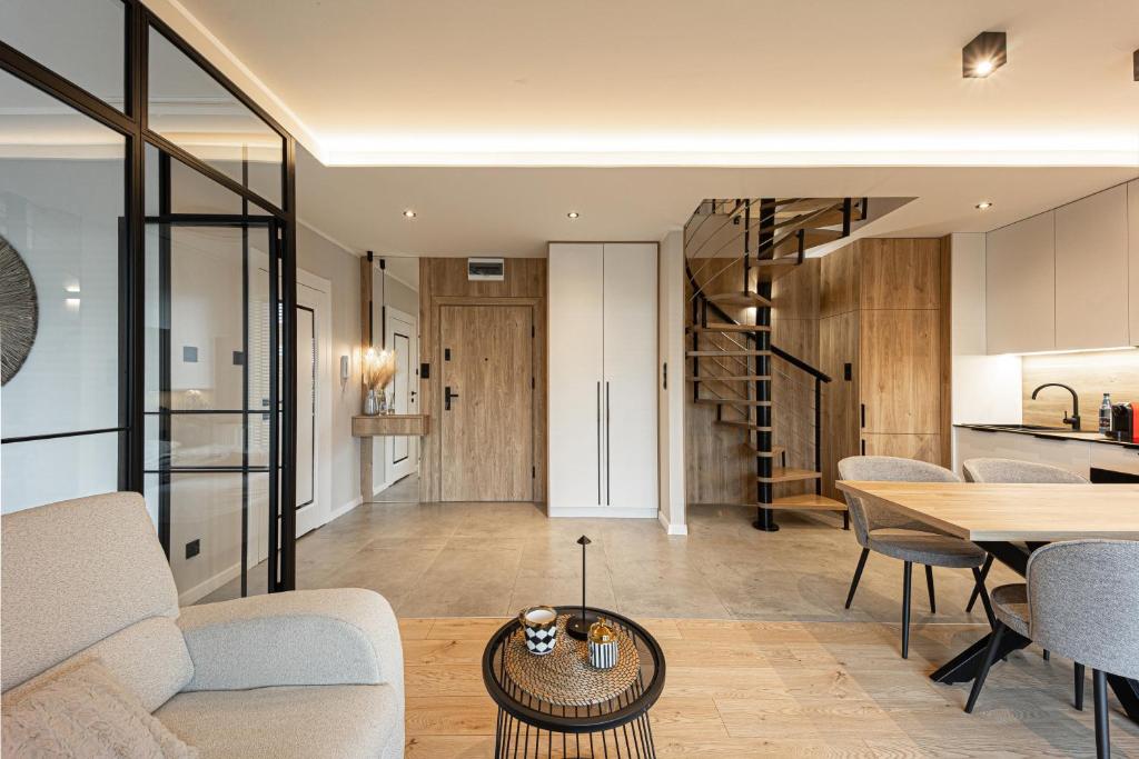 una sala de estar con un sofá y una mesa en Marina Ostróda III - widok na jezioro, podziemny garaż, winda, klimatyzacja, wanna i prysznic, 2 łazienki, lux, en Ostróda