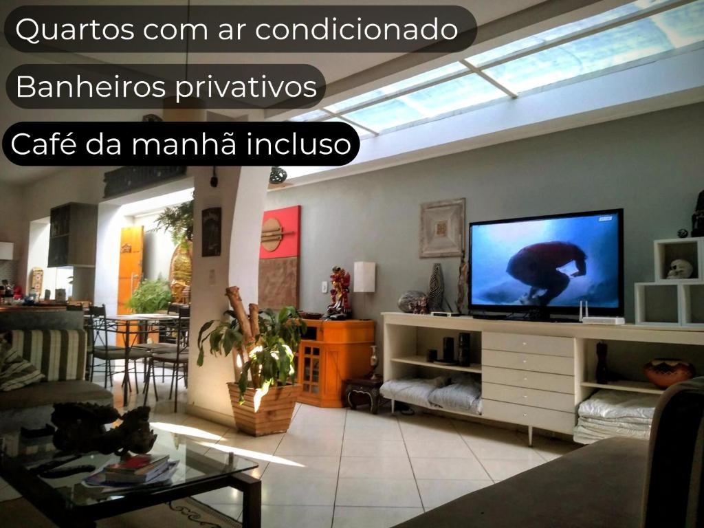 a living room with a flat screen tv on a shelf at Hostel Brooklin in São Paulo