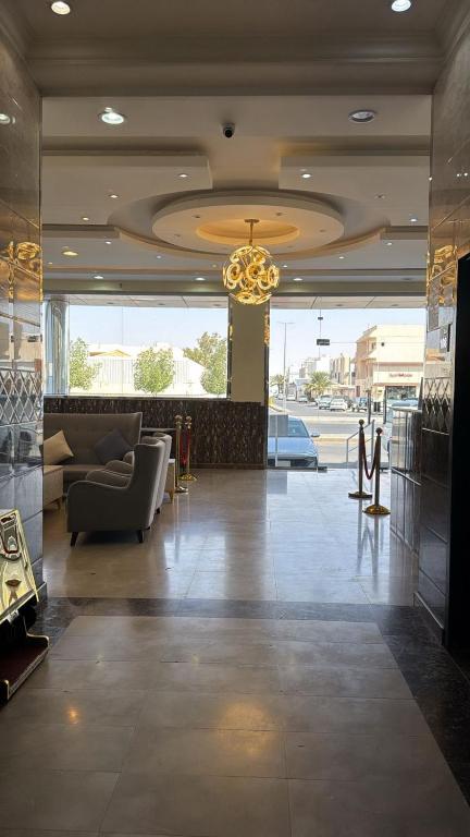 a lobby with a couch and a chandelier at شقق ملفا للشقق الفندقية-شقق مخدومة- اقتصادي2 in Nughaylah