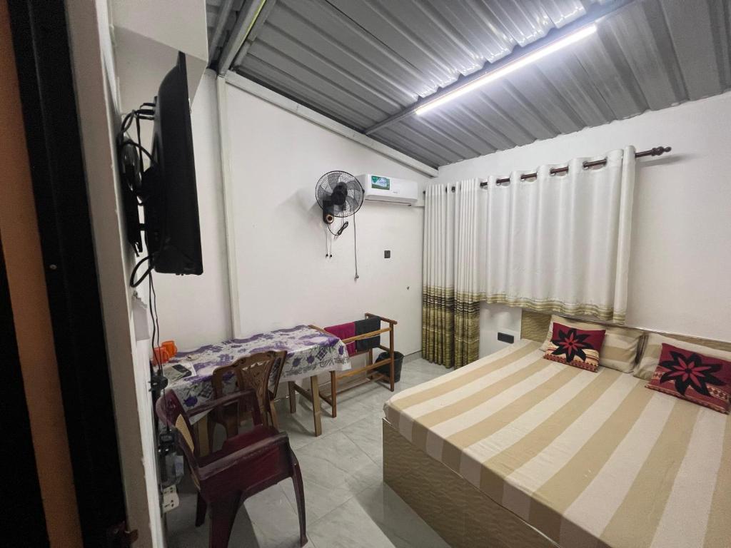 a room with two beds and a tv in it at David Villa in Anuradhapura