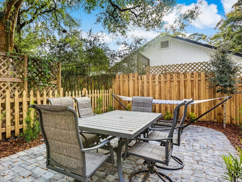 a patio with a table and chairs and a fence at Lazy Hammock in Tybee Island