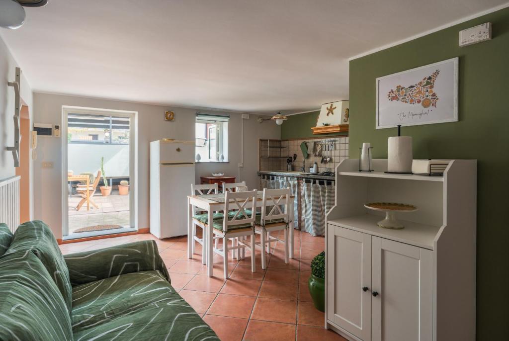 a living room with a couch and a table and a kitchen at Ciauru ri Casa in Mascalucia