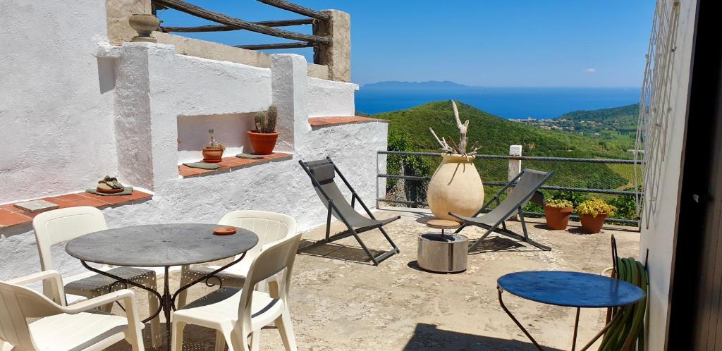 Un patio con mesa y sillas y vista al mar. en Maison de charme avec Terrasse vue sur mer, en Rogliano