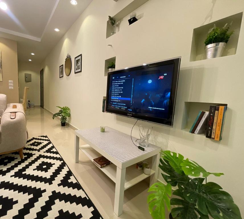 a living room with a flat screen tv on a wall at Modern apartment with garden in Sheikh Zayed