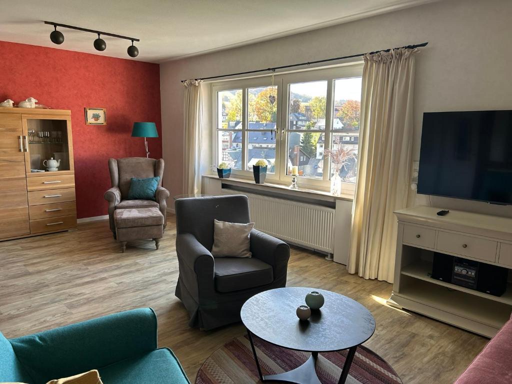 a living room with a couch and a tv at Fewo am Iberg 20, inkl Parkplatz in Willingen
