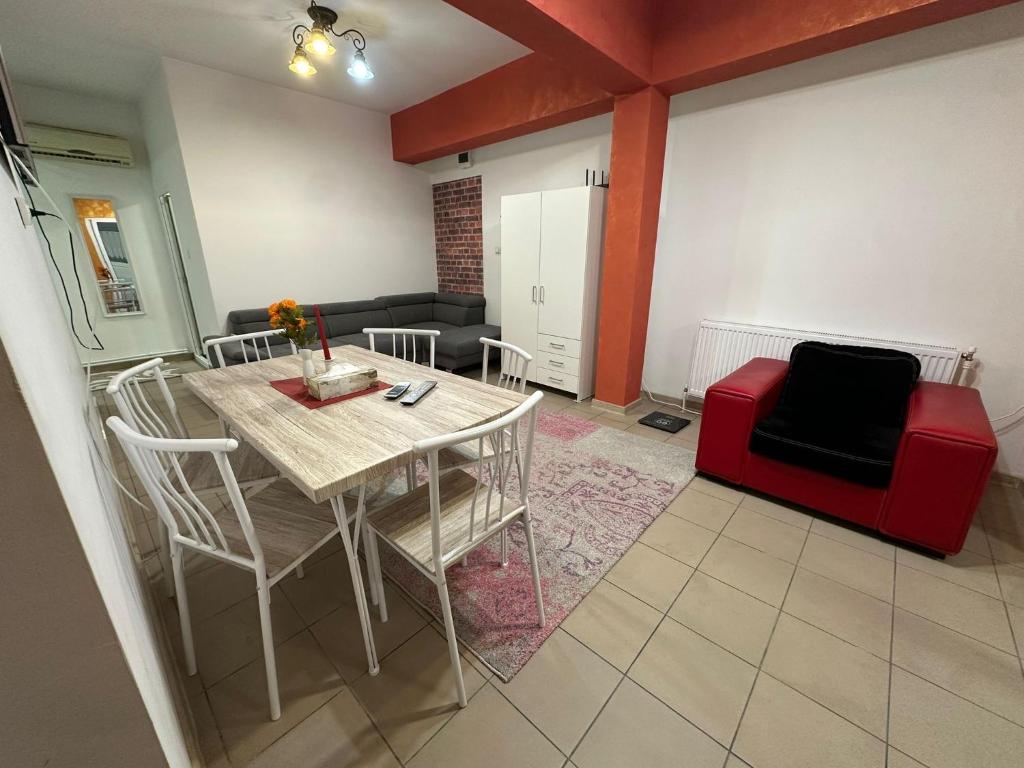 un soggiorno con tavolo e sedia rossa di Smart Stay a Craiova