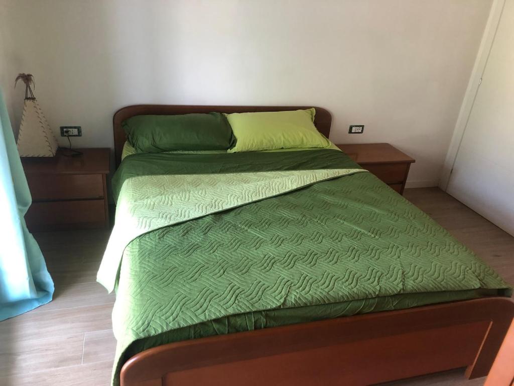 un letto con piumone verde in una camera di Valentinas retreat a San Dorligo della Valle
