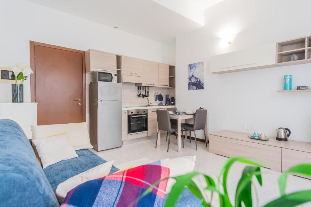 a kitchen and a living room with a couch and a table at La Villa Strangiato in Seregno