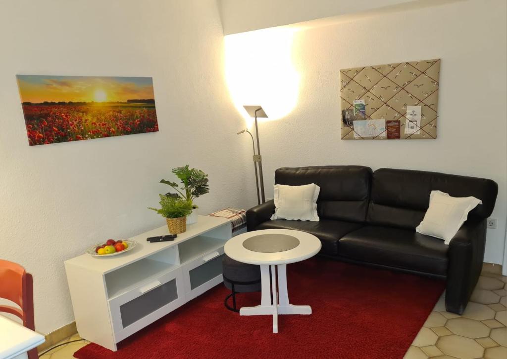 a living room with a couch and a table at Cozy basement apartment in Mettmann in Mettmann
