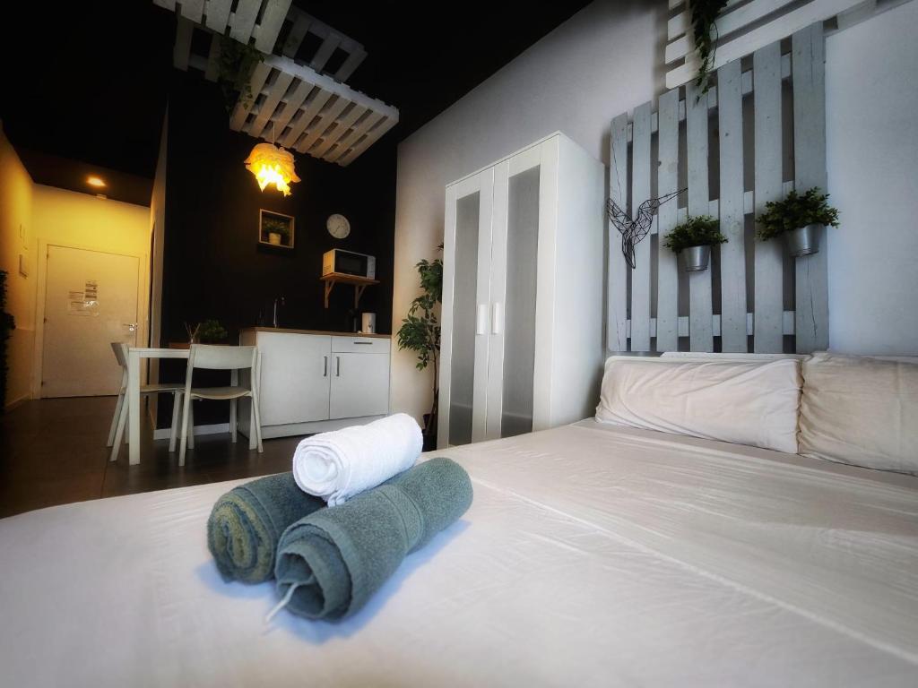 a bedroom with a white bed with towels on it at Cozy Room G20 in Valencia