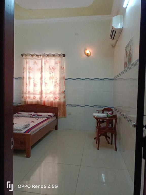 a bedroom with a bed and a table and a window at Lộ Kim Yến in Kon Rung (1)