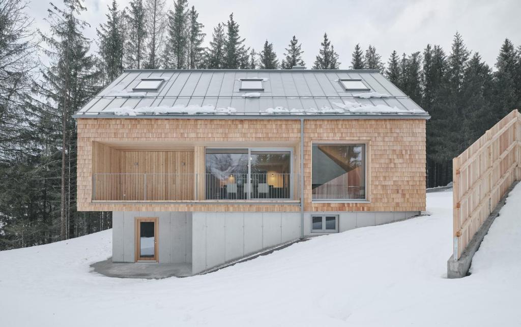 a brick house with a metal roof in the snow at Z91 - Skandi-Architektenhaus mit Bergblick in Bad Mitterndorf