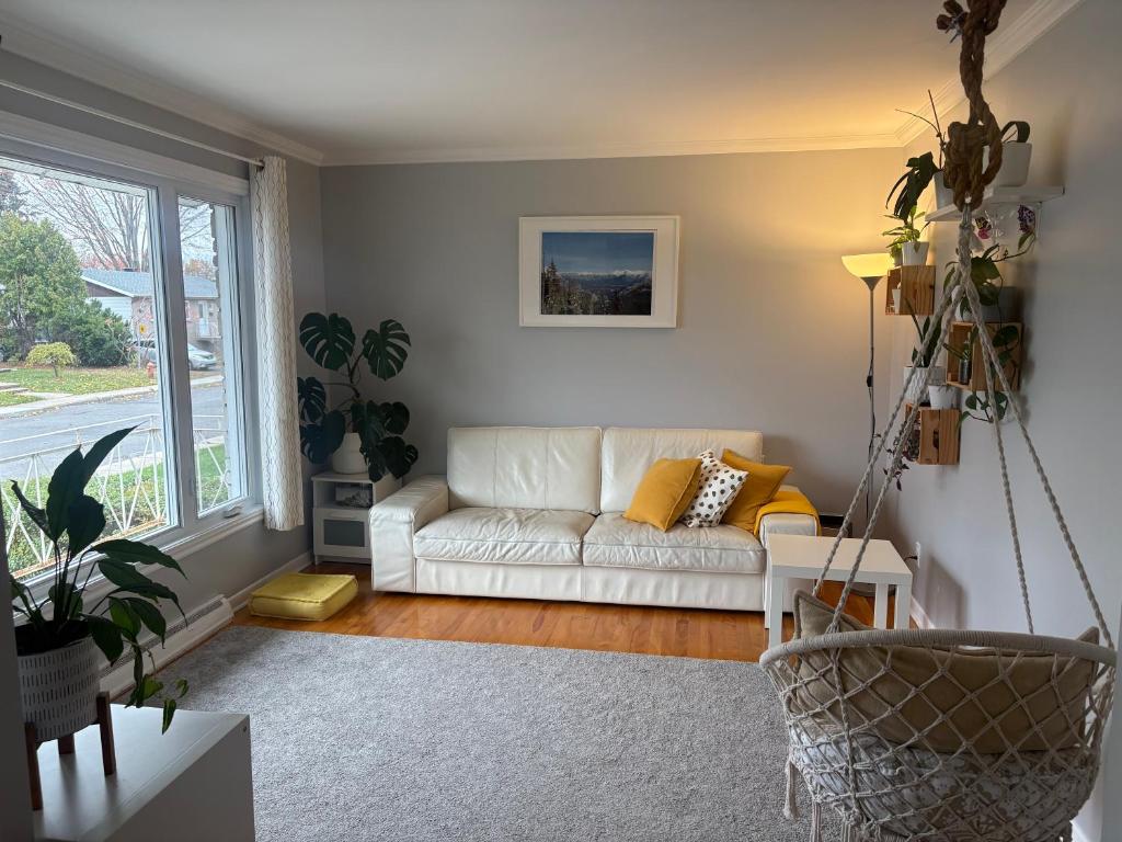 ein Wohnzimmer mit einer weißen Couch und einem Fenster in der Unterkunft Escapade familiale à Longueuil in Longueuil