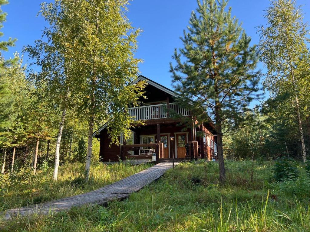 eine Hütte im Wald mit einem Holzsteg davor in der Unterkunft Holiday Home Karhu in Istunmäki