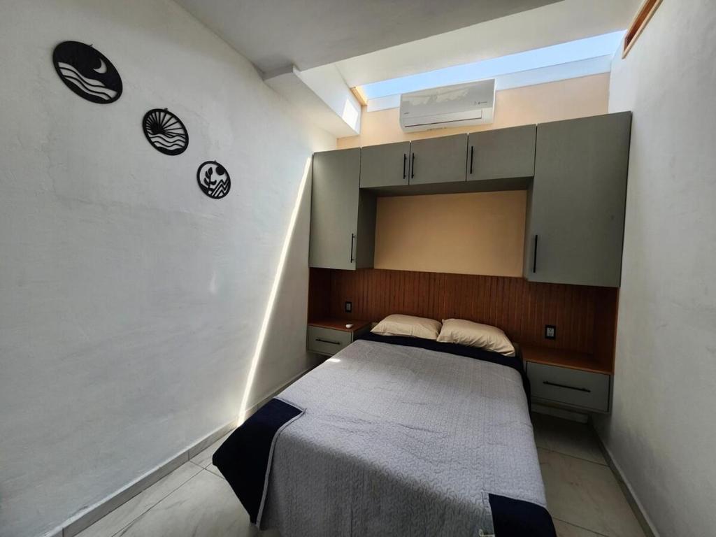 a small bedroom with a bed in a room at Casa Elbatros in Manzanillo