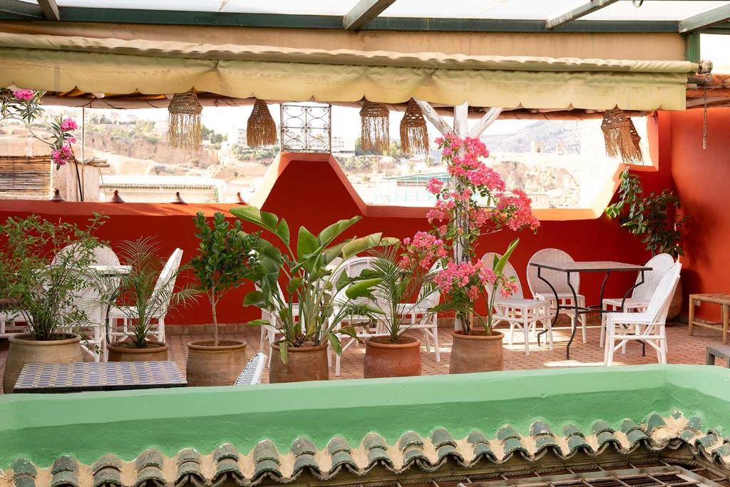 a patio with potted plants and a table and chairs at Riad Ruh Fes in Fès
