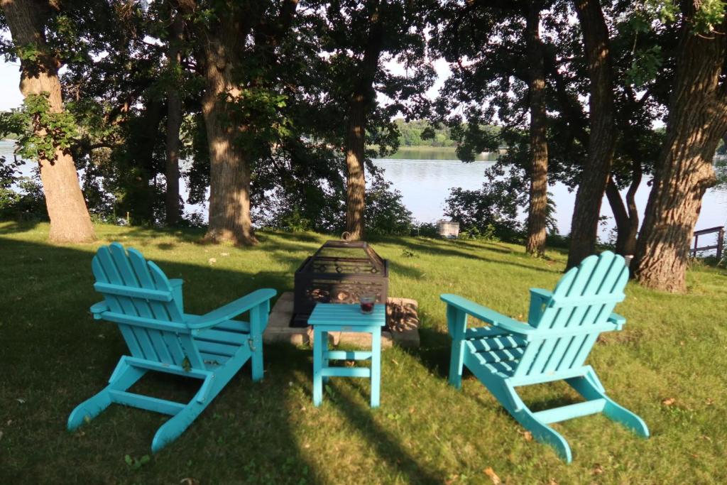 two blue chairs sitting in the grass near a fire hydrant at Legacy Lakehouse in Spicer