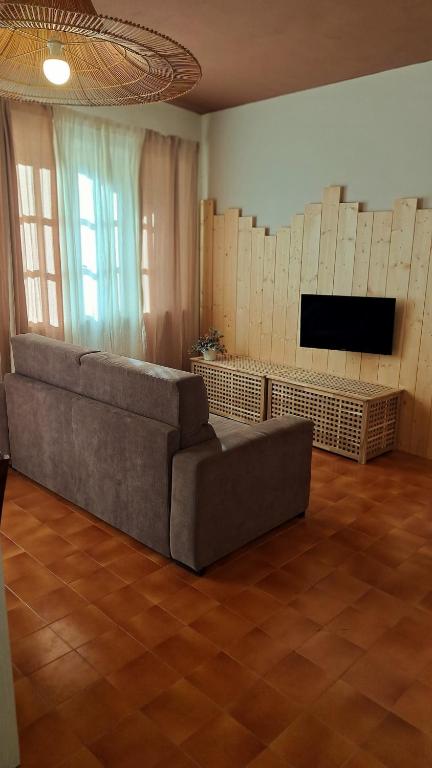 a living room with a couch and a flat screen tv at Da Nonna Isa - Ampio appartamento tra Bormio e Bernina Express in Grosotto