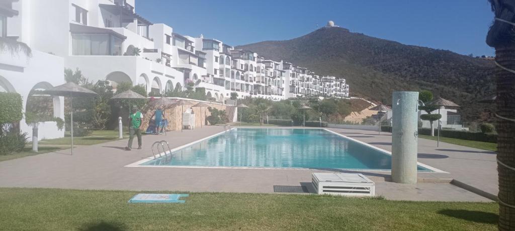 una gran piscina frente a un edificio en Bel appart lumineux avec vue imprenable sur la mer et la montagne, en Cabo Negro
